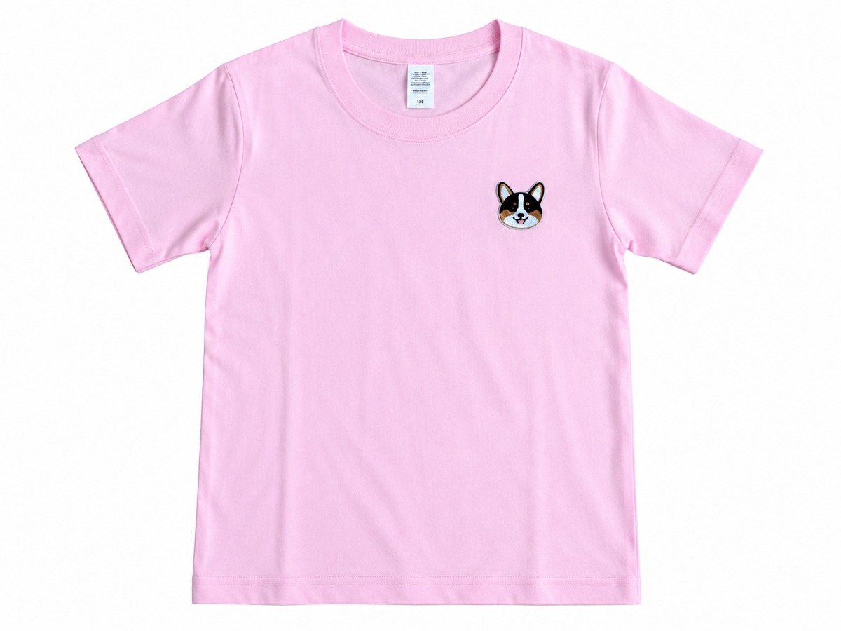 A light pink short-sleeve crewneck t-shirt featuring a small embroidered corgi face patch on the left chest, displayed flat against a white background.