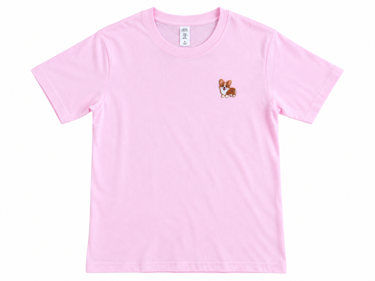 A light pink short-sleeve crewneck t-shirt featuring a small embroidered corgi dog graphic on the left chest, displayed flat against a white background.