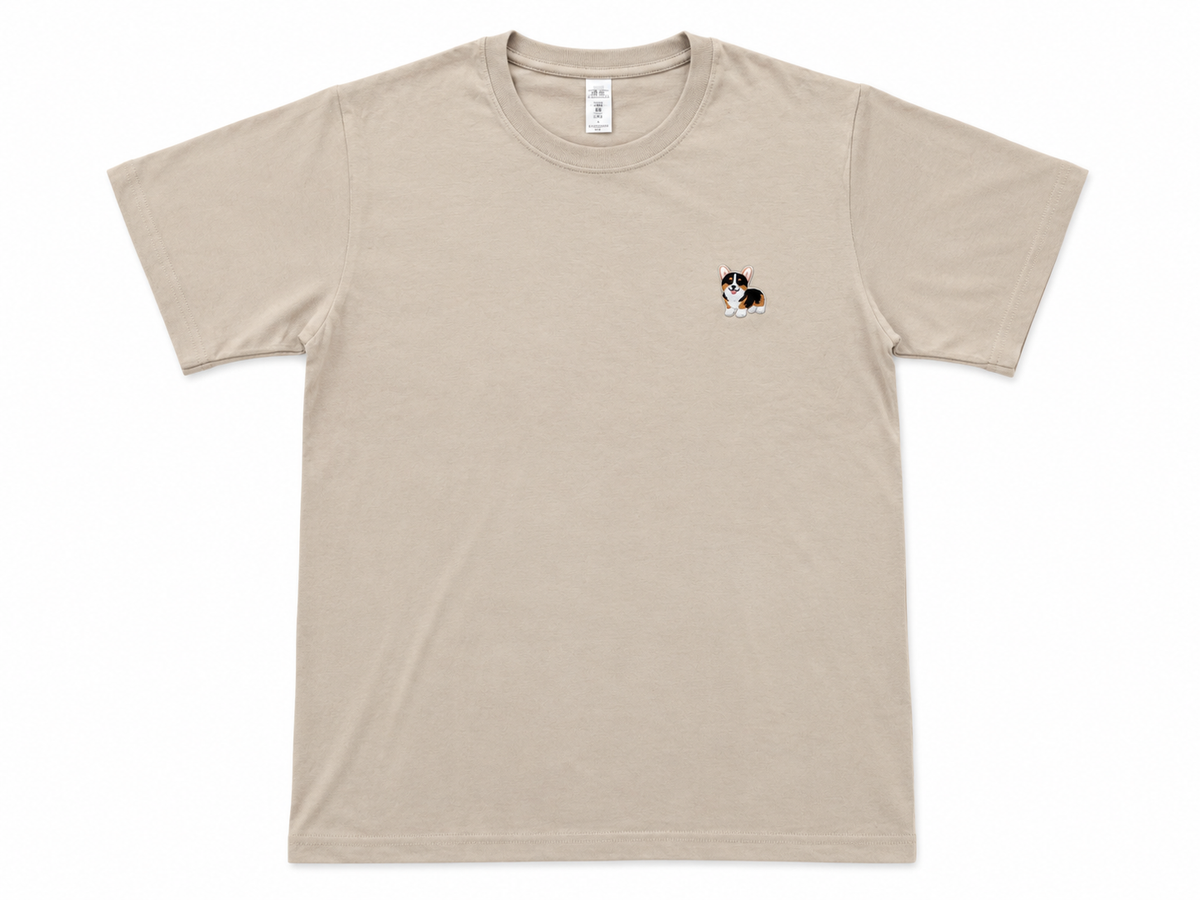 A light beige crewneck t-shirt with a small cartoon dog graphic on the left chest, displayed flat against a white background.