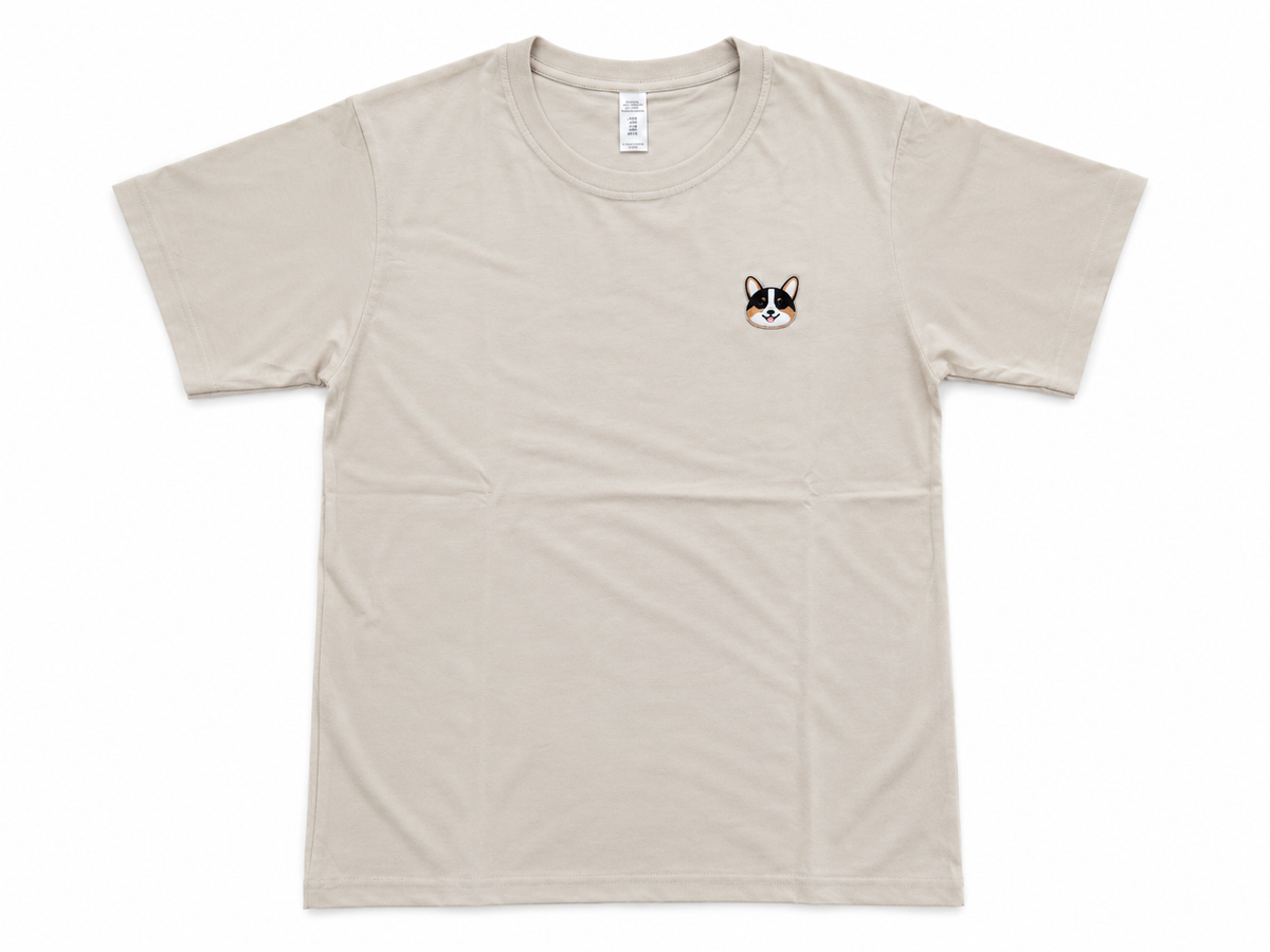 A light beige crewneck t-shirt with a small embroidered French Bulldog face on the left chest, displayed flat against a white background.