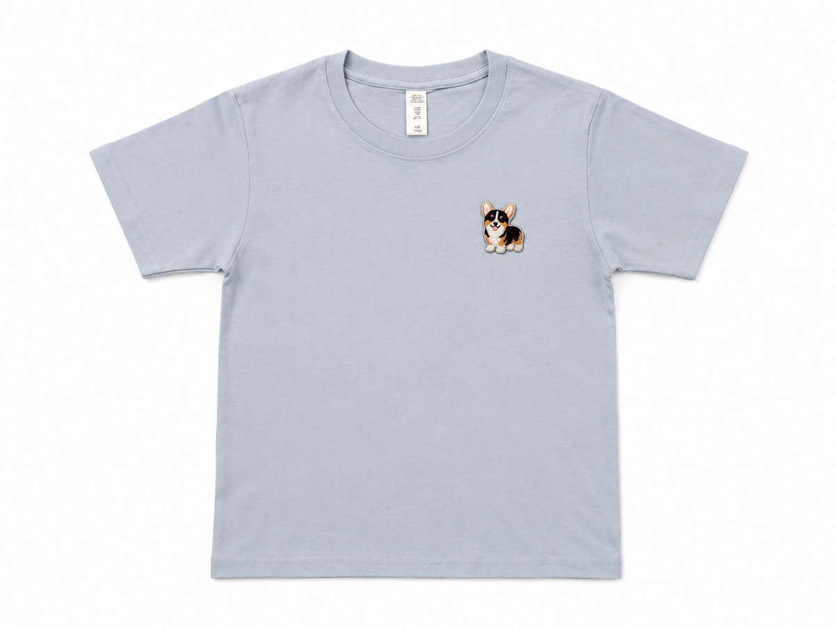 A misty blue short-sleeve crewneck t-shirt featuring a small embroidered corgi dog graphic on the left chest, displayed flat against a white background.