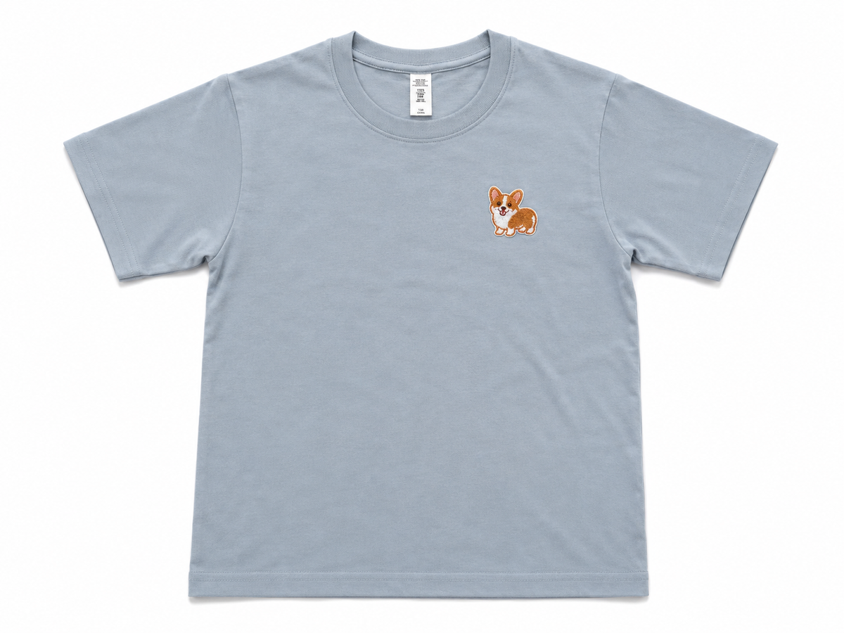 A misty blue short-sleeve crewneck t-shirt featuring a small embroidered cartoon corgi on the left chest, displayed flat against a white background.