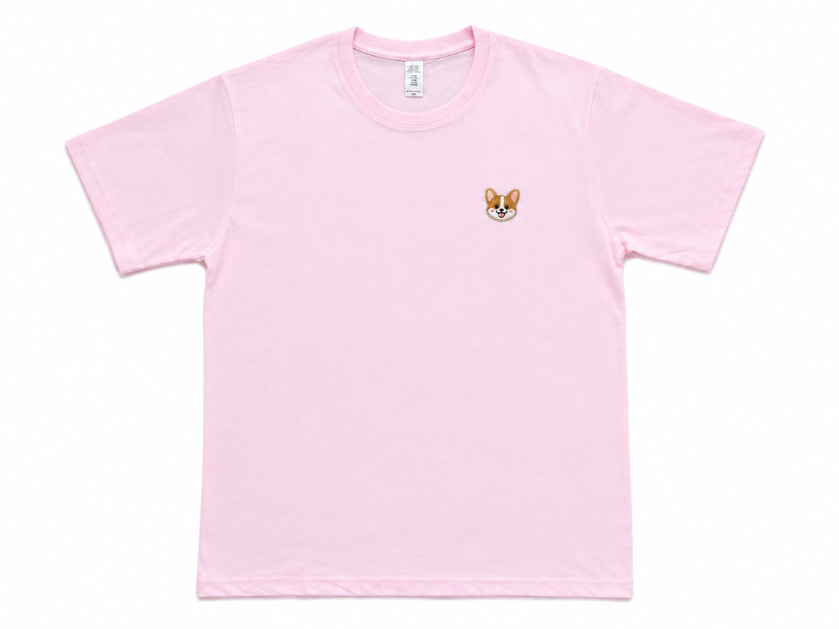 A light pink short-sleeve crewneck t-shirt with a small embroidered corgi face on the left chest, displayed flat against a white background.