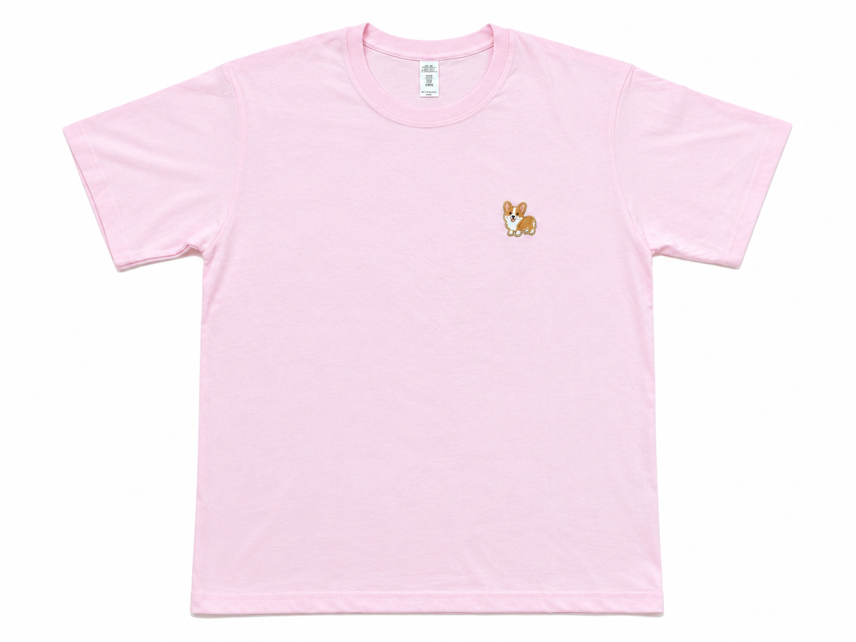 A light pink short-sleeve crewneck t-shirt with a small embroidered corgi dog on the left chest, displayed flat against a white background.