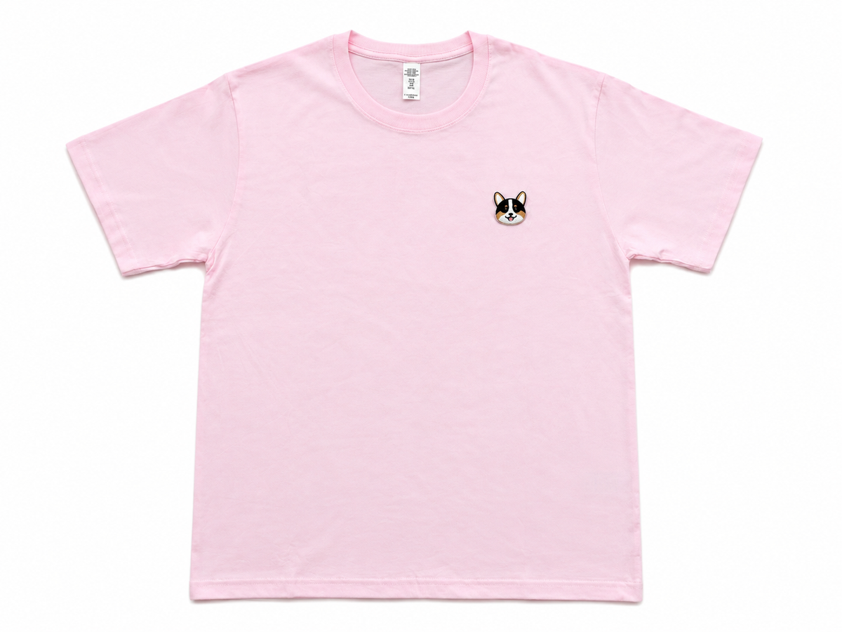 A light pink short-sleeve crewneck t-shirt with a small embroidered corgi face on the left chest.